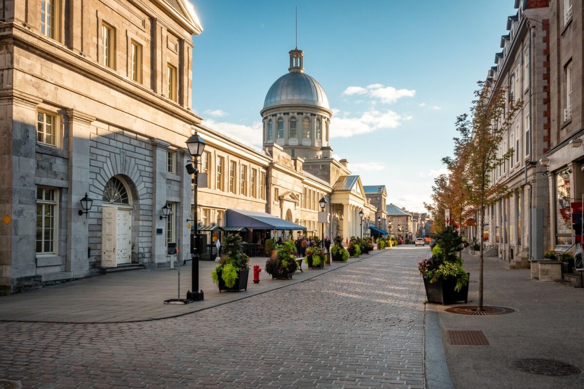Kopfsteingepflasterte Straße in Vieux-Montréal mit der Kuppel des Marché Bonsecours