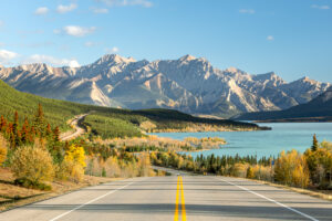 Icefields Parkway mit Blick auf einen Bergsee, herbstliche Wälder und die kanadischen Rocky Mountains